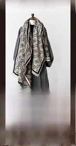 Détail d'une écharpe pashmina avec motif floral traditionnel noir sur fond beige