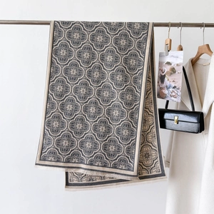 Vue détaillée de la texture florale jacquard et des franges de l'écharpe sur cintre
