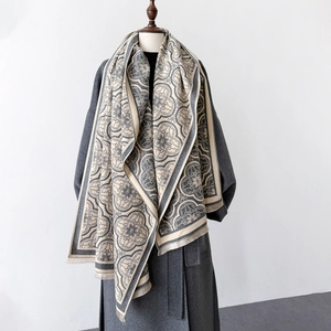 Gros plan sur un châle en tricot épais avec motifs floraux rétro et détails de franges