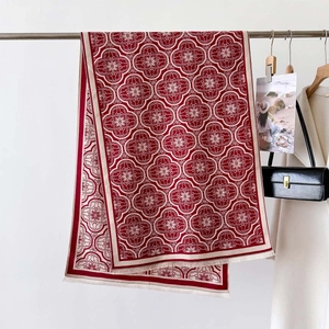 Détail d'une écharpe jacquard rouge et crème avec des franges délicates et texture douce