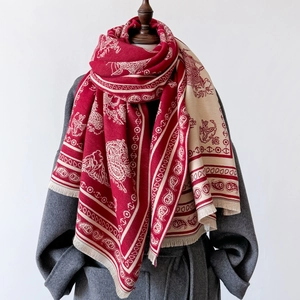 Vintage paisley pattern red and beige cashmere shawl with tassels on a mannequin
