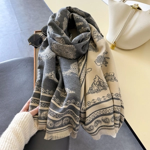 Close-up of exotic elephant jacquard patterns and soft fringe detail on thick wool scarf