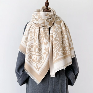 Écharpe épaisse en simili-cachemire jacquard beige à franges sur un manteau en laine sombre