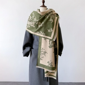 Detail of green and beige cashmere shawl with traditional bamboo pattern and tassels