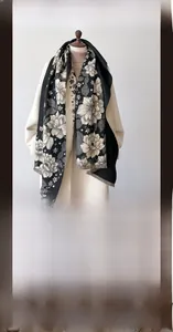 Close-up of imitation cashmere winter scarf featuring large beige floral patterns and fringes