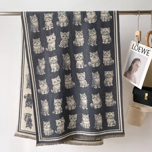 Detail of cute jacquard cat pattern and fringed edges on a thick dark grey winter scarf