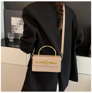 Detailansicht einer schicken rosa Box-Handtasche mit goldfarbenen Beschlägen und M-Logo