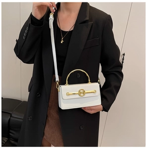 Detailansicht der weißen Box-Tasche mit goldenem Bambusgriff und M-Logo-Metallverschluss