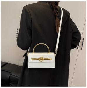 Detail der weißen Lackleder-Handtasche mit goldenem Bambusgriff und M-Logo am Modell