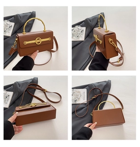 Detail der dunkelbraunen Box-Tasche mit goldenem Bambusgriff und M-Metallschließe