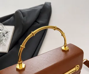 Detailed shot of brown leather handbag with vintage golden bamboo design handle