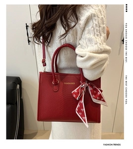Détail du sac cabas rouge aspect serpent avec foulard à cœurs et bandoulière réglable