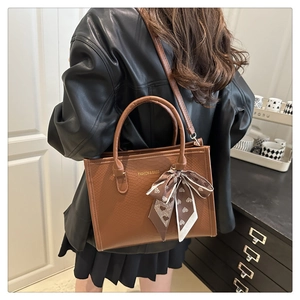 Sac fourre-tout marron à motif croco avec foulard décoratif dans un cadre intérieur moderne