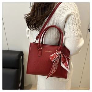 Détail du sac cabas rouge à motif serpent avec foulard cœur et bandoulière amovible