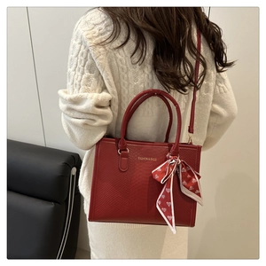 Gros plan détaillé du sac cabas rouge avec texture serpent et décoration en soie