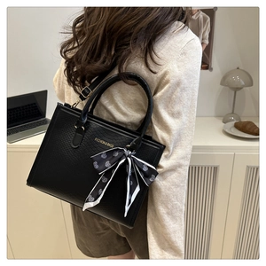 Détail du sac cabas noir gaufré avec lettrage doré et foulard décoratif en soie à cœurs