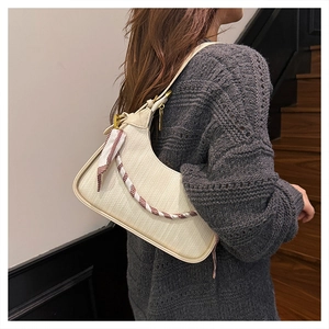 Detail of creamy white leather hobo bag with textured lychee grain and silk scarf handle
