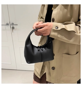 Detailed view of a black crescent handbag featuring dual zippers and matte finish