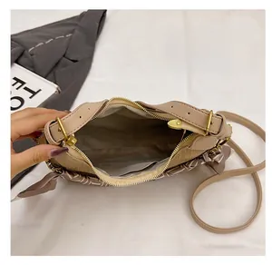 Detail showing the interior compartment of the beige tote bag with a golden zipper and silk scarf