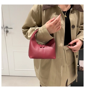 Close-up of deep wine red leather half-moon bag with elegant stitching and dual zippers