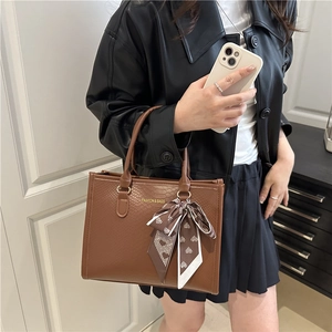 Grand sac cabas marron à motif serpent avec foulard à cœurs présenté sur un mannequin