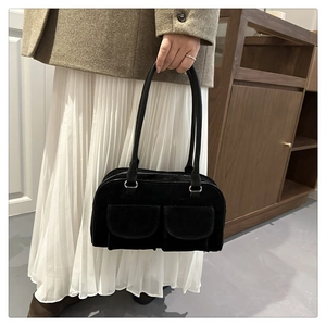 Detail of a vintage black suede tote bag with double front flap pockets and silver hardware