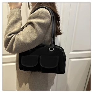 Close-up of black multi-pocket shoulder bag with silver hardware and vintage texture