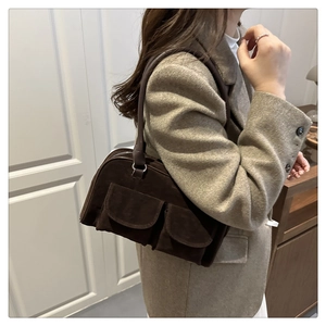 Detail of the dual front pockets and suede texture on this retro brown tote bag