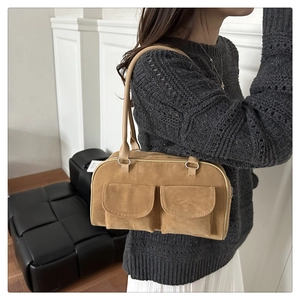 Detail of khaki frosted suede underarm bag with double front flap pockets and silver rings