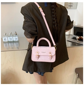 Detailed view of pink snakeskin pattern small crossbody bag with gold hardware