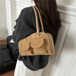 Brown suede shoulder bag with two front pockets and double handles shown on model