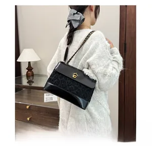 Detail of classic black quilted shoulder bag with gold twist lock and chain strap