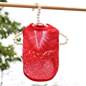 Detalle del chaleco de malla roja para perro con estampado de fresa en percha