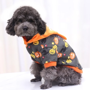 Detail of Halloween pet hoodie featuring orange pumpkins and wizard hats on gray fabric