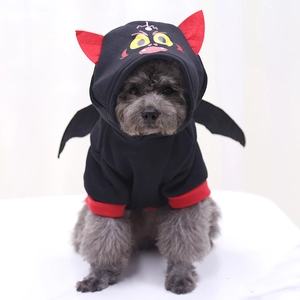 Detail of bat-themed pet hoodie with red horns, cartoon print, and black wings