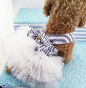 Detail view of pet dog dress featuring a blue striped bow with gold beads and white mesh skirt