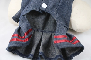 Detail of dark blue denim pet dress featuring sailor-style red stripes and snap button