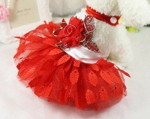 Detail of red pet party dress with large 3D flowers and sparkling leaf-shaped sequins