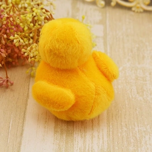 Cute yellow plush duck dog toy with squeaker shown from a rounded back view perspective