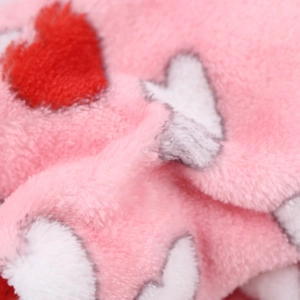 Close-up of soft pink flannel fabric with red and white heart patterns for pet clothing
