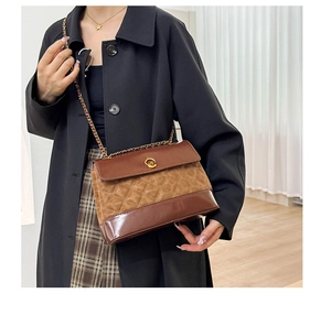 Detail of brown quilted chain bag with vintage gold twist lock on black coat