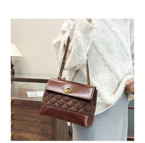 Detail of vintage brown quilted stitching on faux leather shoulder bag with gold hardware