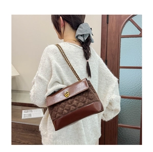 Detail of vintage brown quilted shoulder bag with gold chain and metal twist-lock