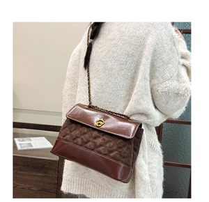 Detail of vintage brown quilted shoulder bag with gold clasp and chain strap