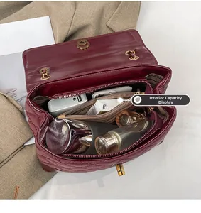Detail of the spacious interior compartment and gold clasp on the quilted wine red bag
