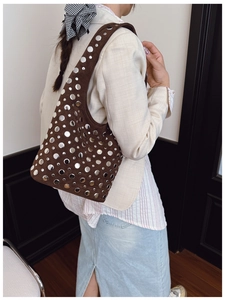 Dettaglio borsa a secchiello in camoscio testa di moro con borchie punk e stile boho