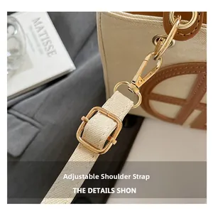 Detail of adjustable leather strap with golden metal hardware on canvas tote bag