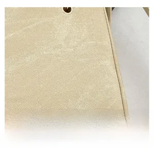 Macro shot of beige Saffiano leather texture with fine stitching and golden eyelet