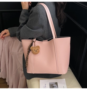 Pink tote bag detail with lychee grain texture and cute plush bear charm with scarf