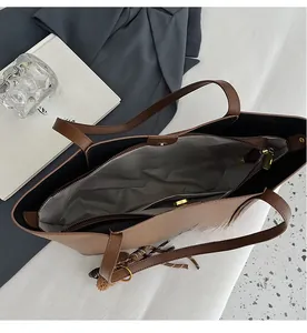 Interior view of brown tote bag showing multi-compartment design and gold magnetic closure
